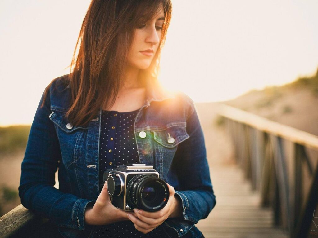 Fotógrafa de Love+Love con su cámara al atardecer